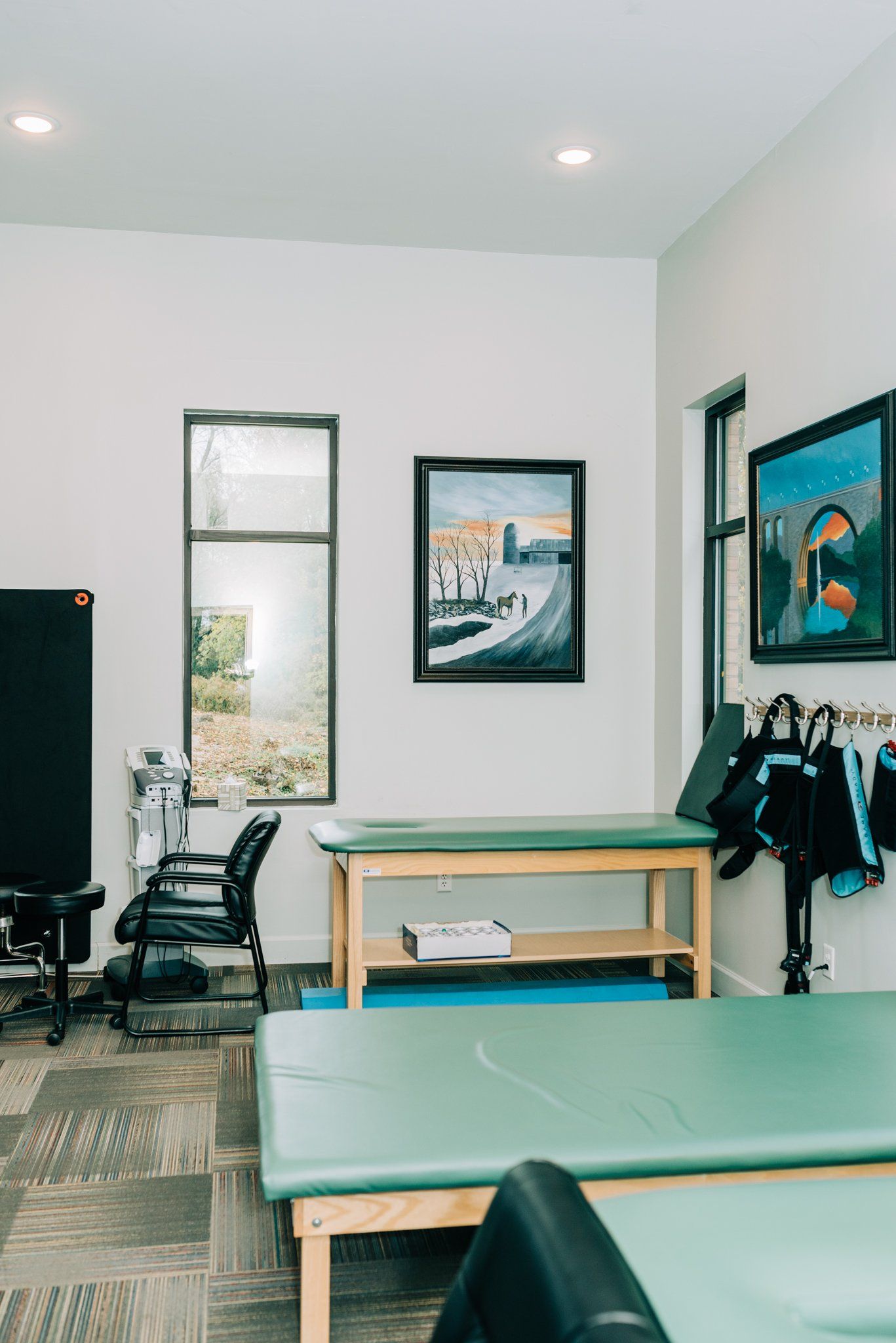 A room with a lot of tables and chairs and a painting on the wall.