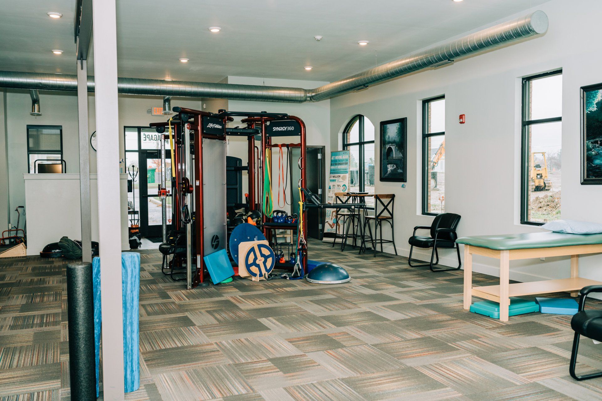 A large room with a lot of exercise equipment in it.