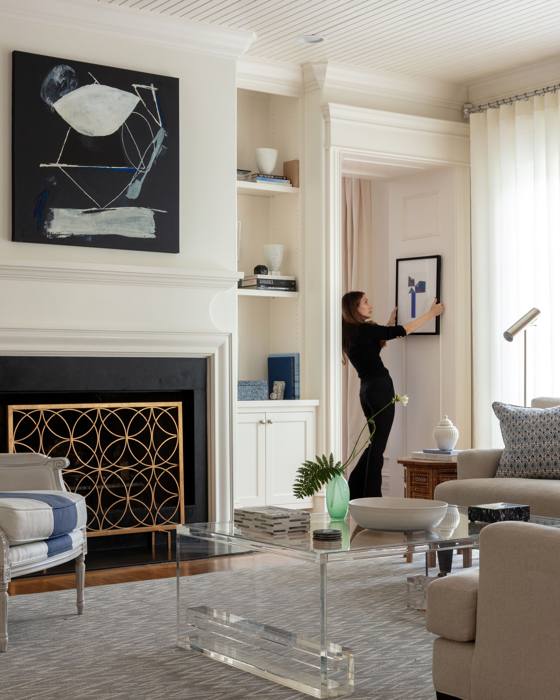 A gorgeous living room with Carrie hanging a picture frame