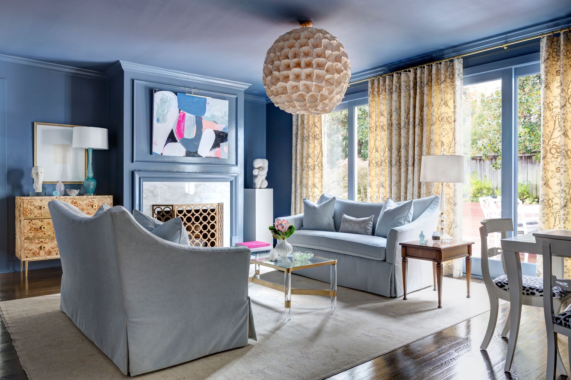 A blue color drenched living space featuring pops of color in the decor 