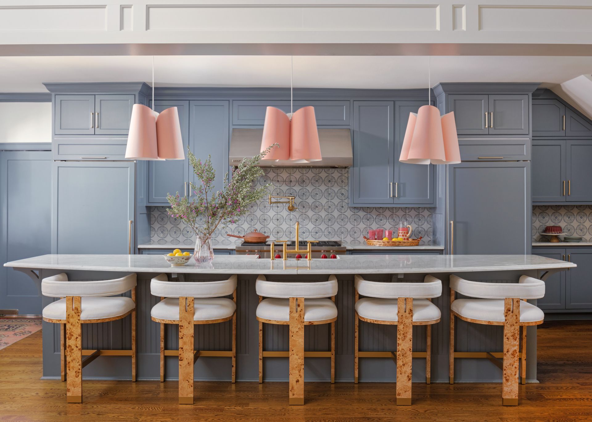 A blue kitchen featuring burlwood chairs and pink lights