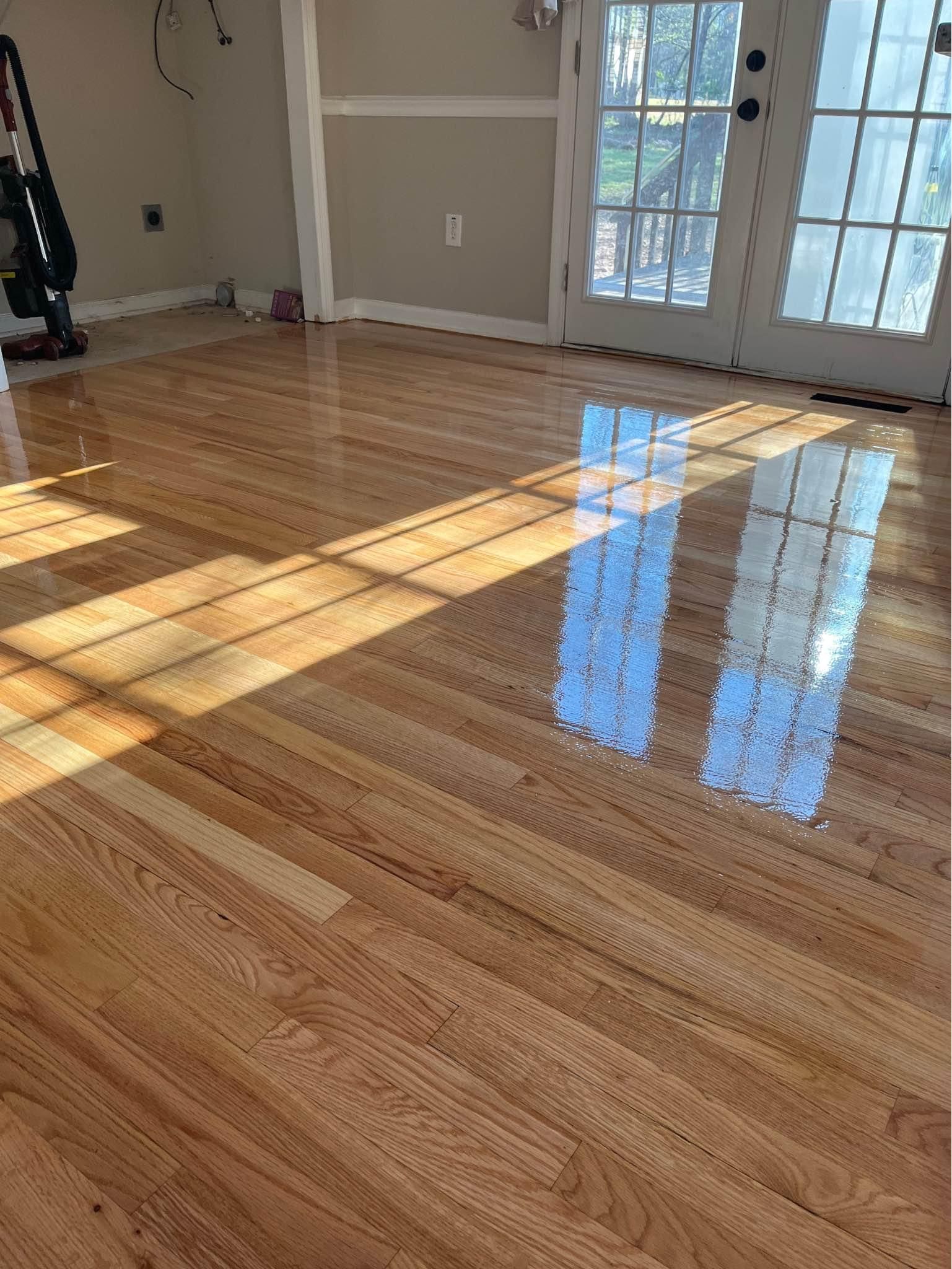 A living room with hardwood floors and a vacuum cleaner.