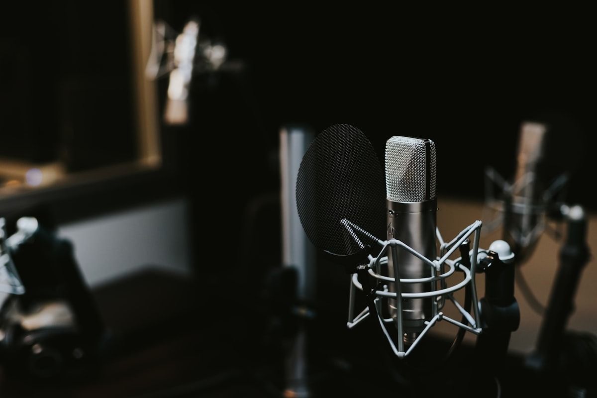 Studio microphone with pop filter and shock mount in a dark recording setup