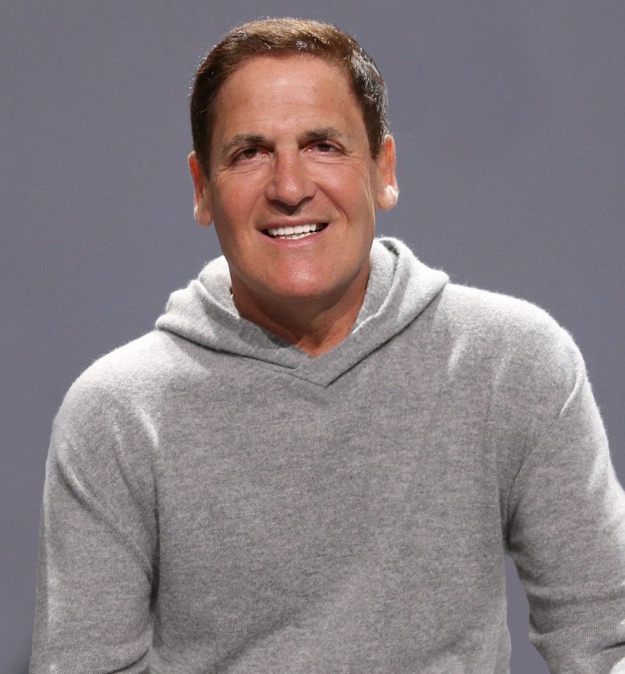 Smiling person in a light gray hoodie against a plain gray background