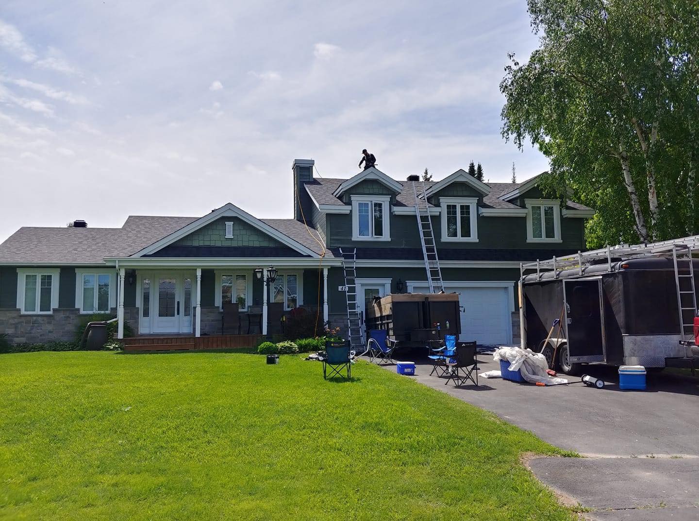 Serre avec des ouvriers sur le toit en cours de rénovation. Allée et pelouse devant.