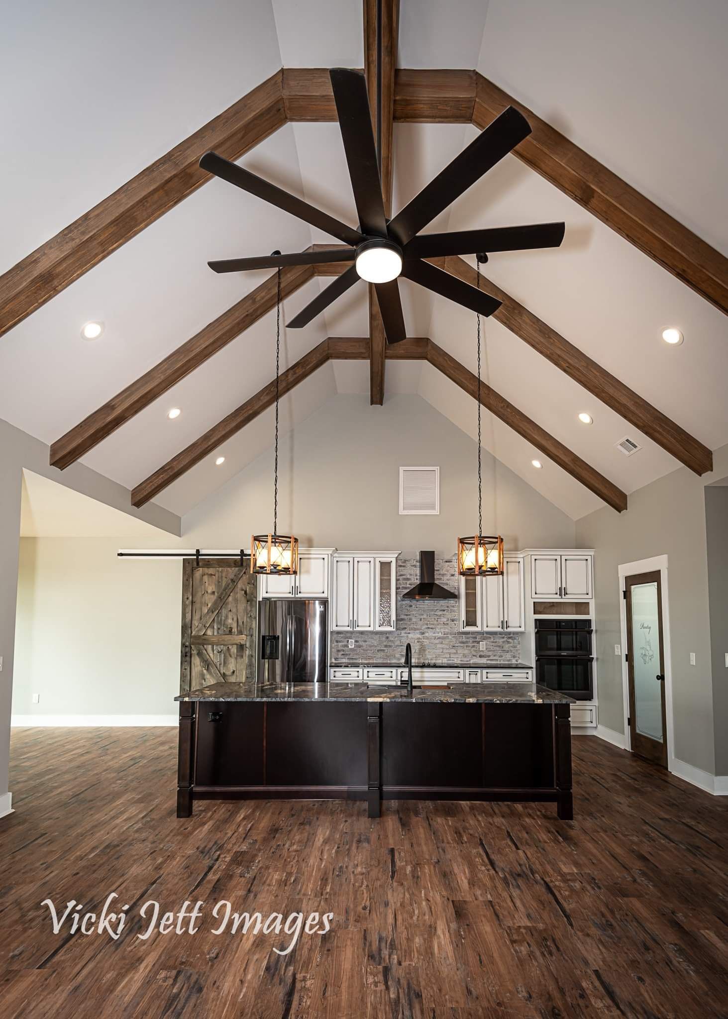 A kitchen with a large island and a ceiling fan.