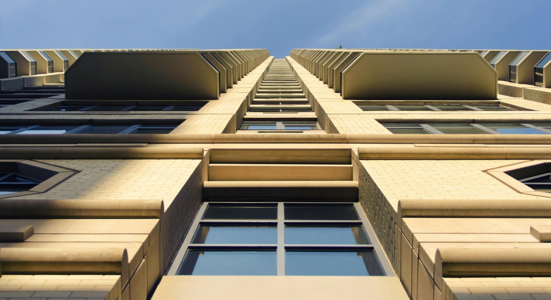 Looking up at a tall building with a blue sky in the background