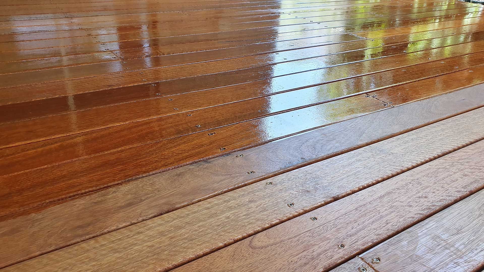 A close up of a wooden deck with a shiny finish.