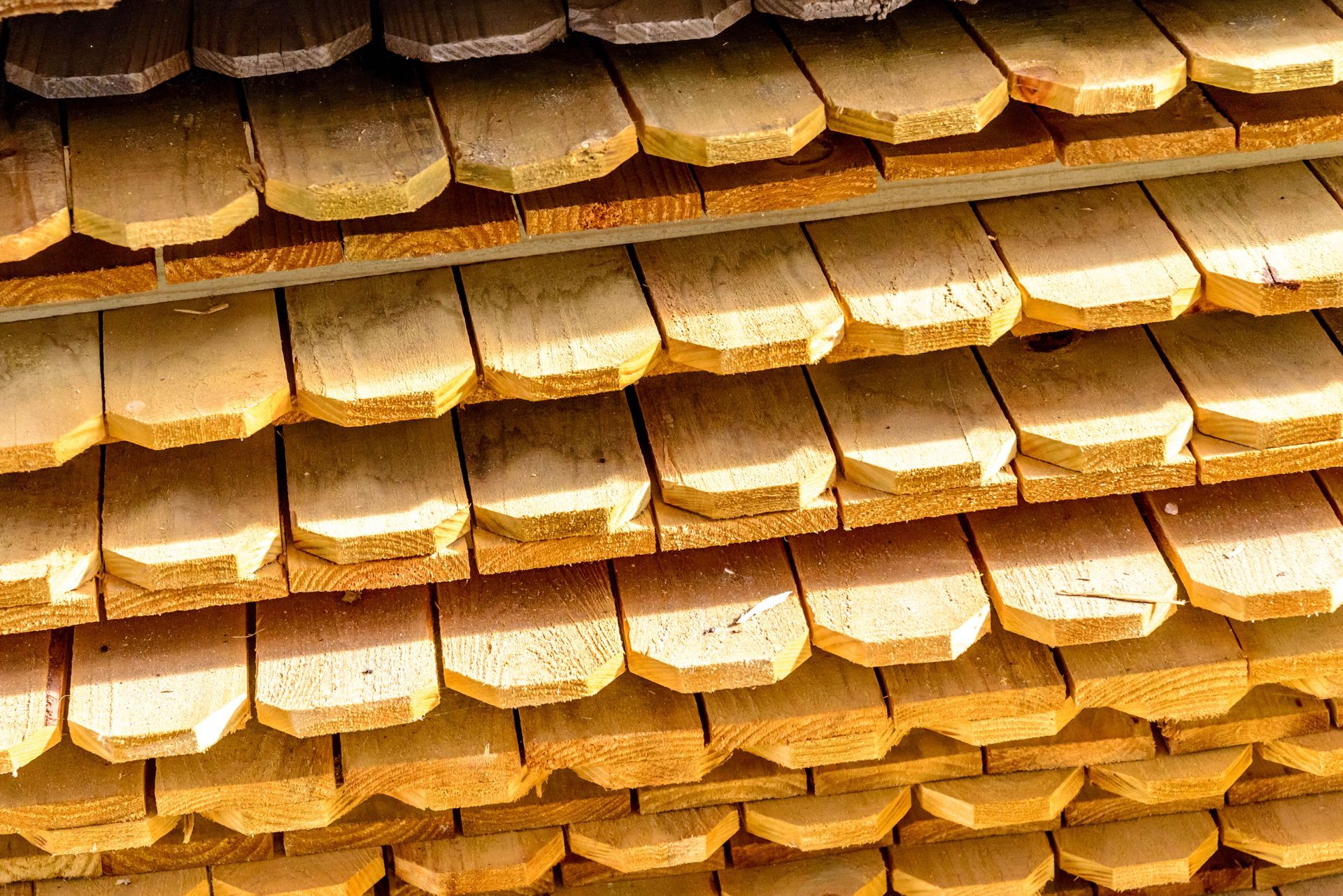 Stack of wooden shingles, light brown, with rounded ends, ready for use. Stack of wooden shingles, light brown, with rounded ends, ready for use.