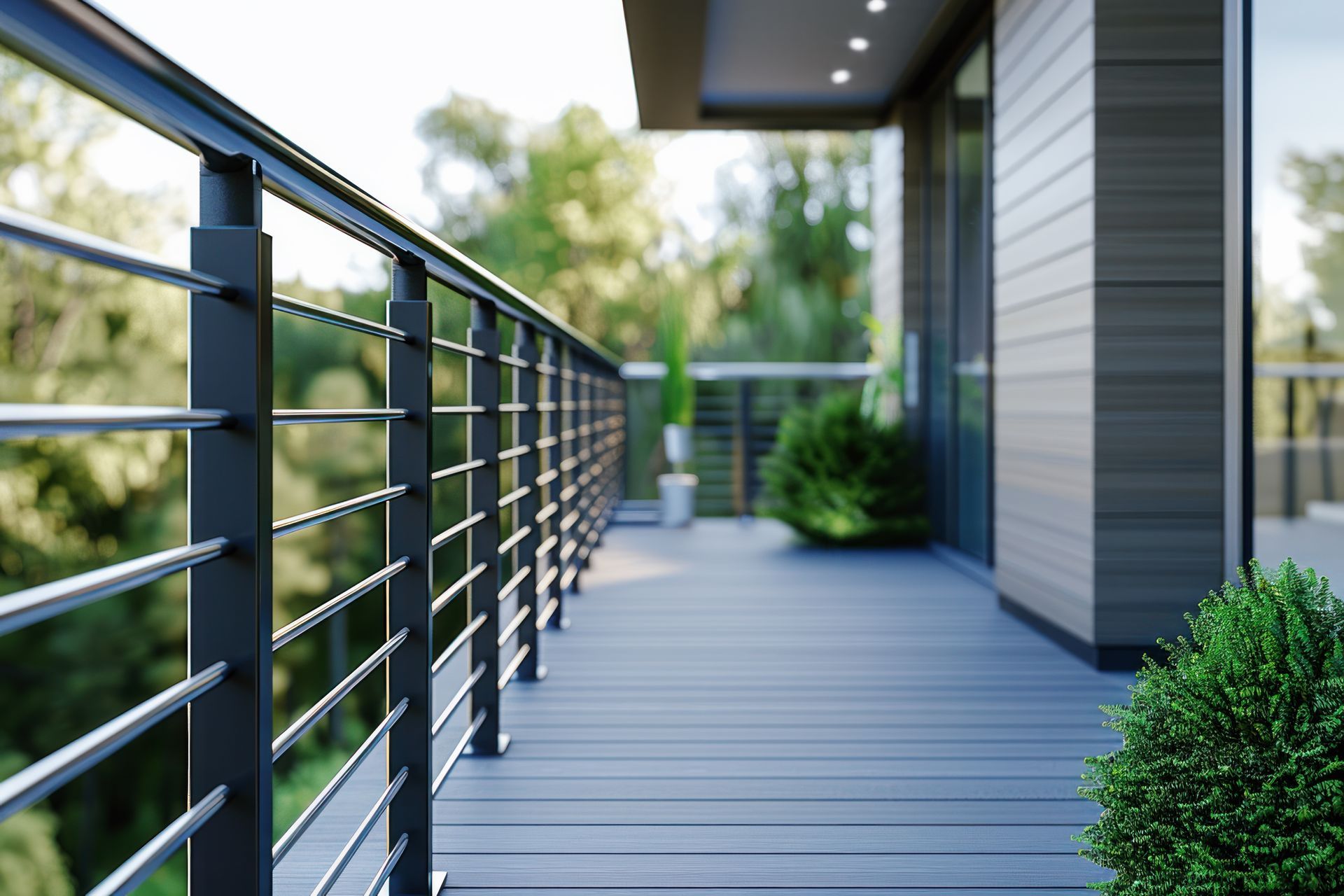 Modern balcony with black railings and composite decking, overlooking a green landscape.
