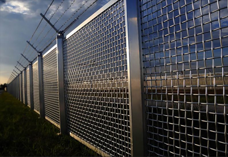 A wire fence with barbed wire on top of it