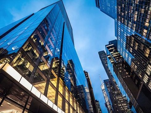 Skyscrapers with glass facades towering against a blue sky in a city canyon
