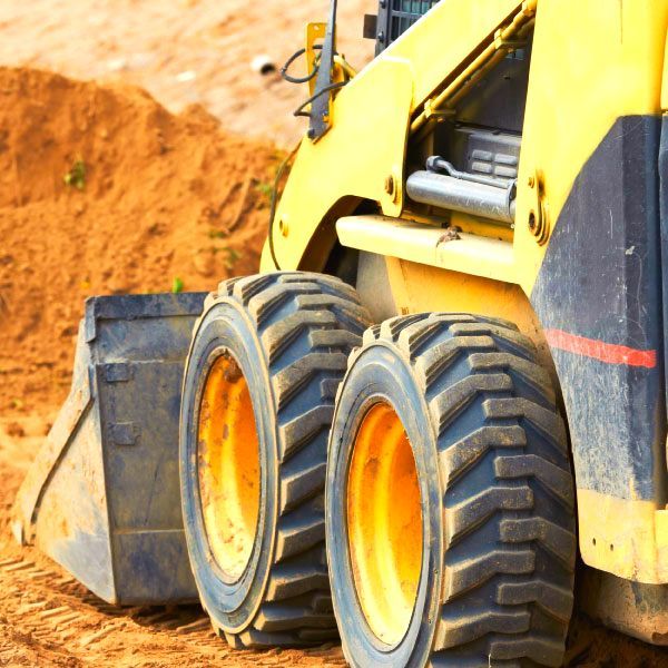 Chargeuse de chantier jaune à grandes roues sur un chantier de terre