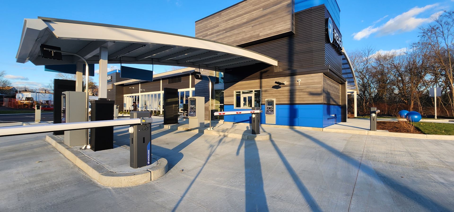 A blue and brown building with a parking lot in front of it.