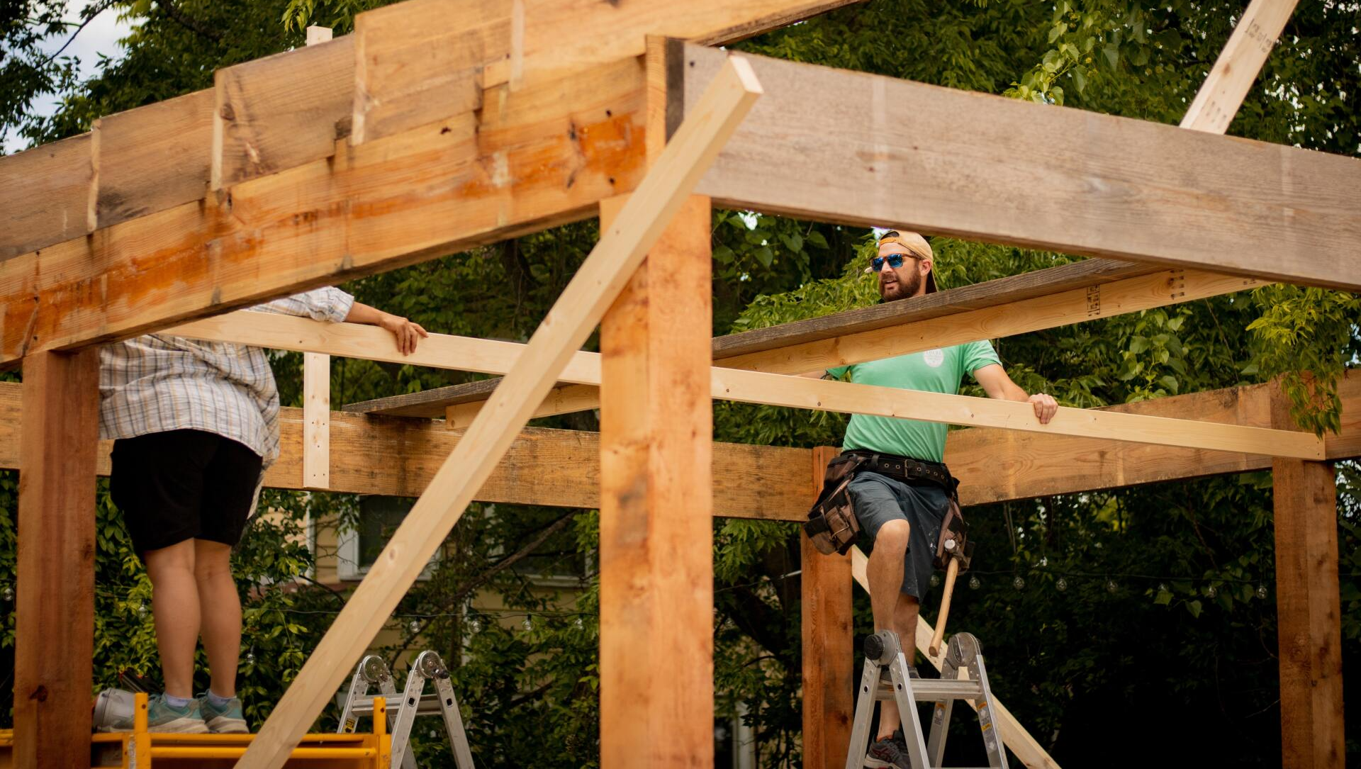 A group of people are working on a wooden structure