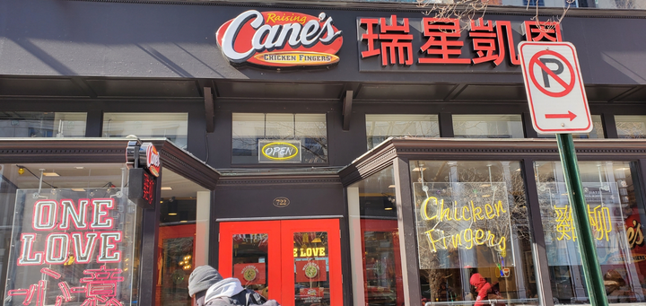 Raising Cane's restaurant storefront with red doors, 