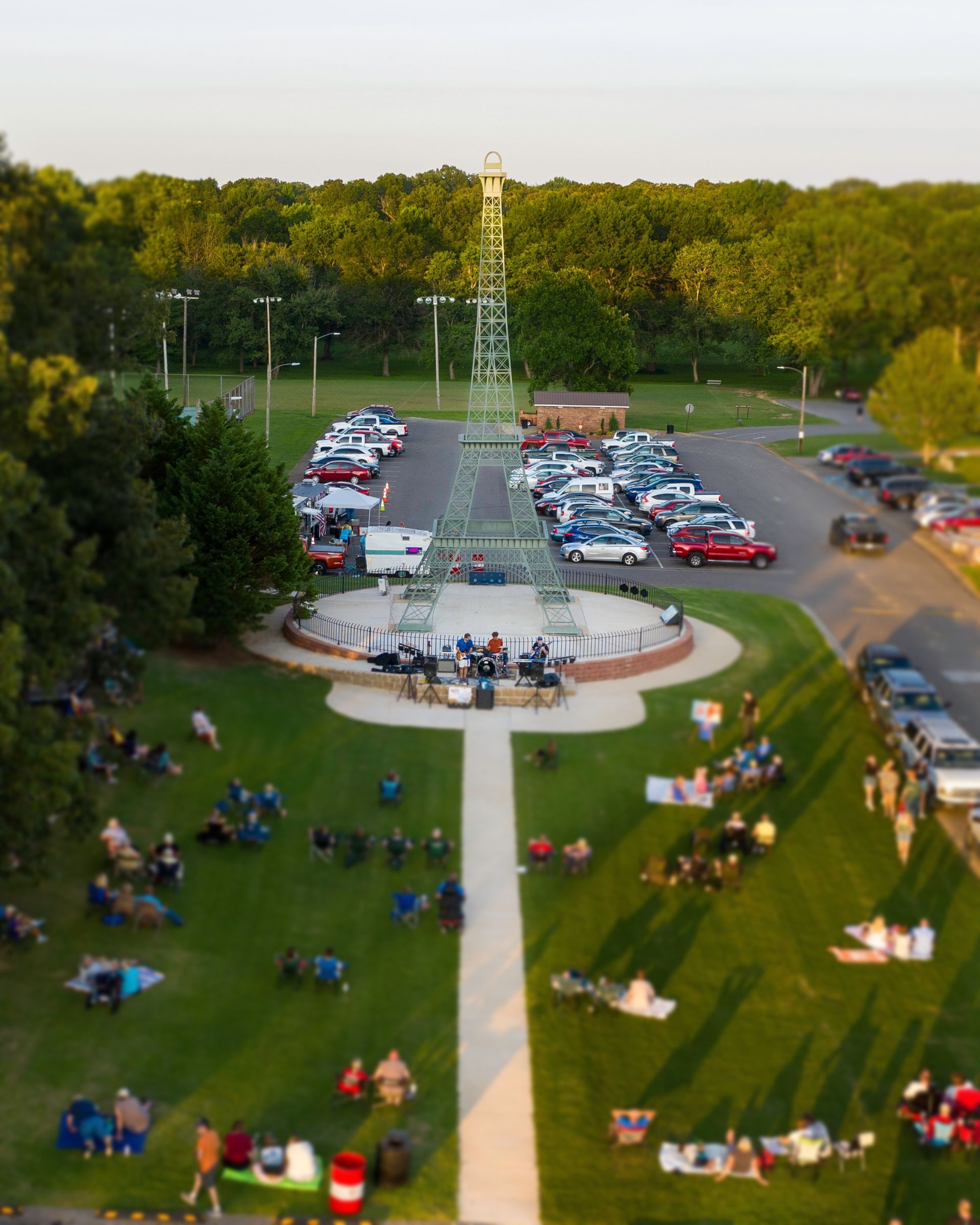 An aerial view of a park filled with people and cars