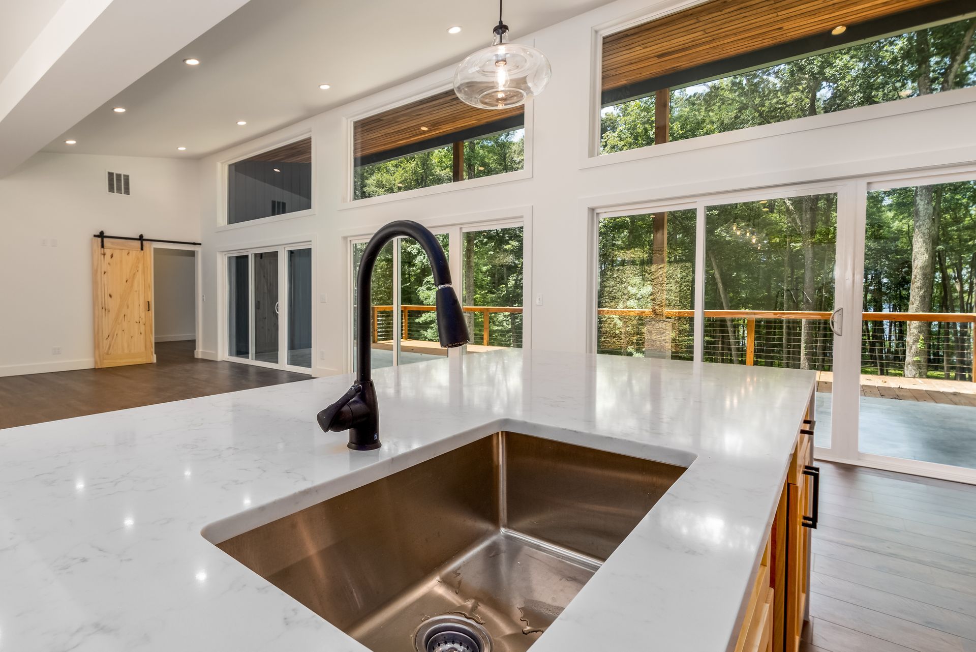 A kitchen with a stainless steel sink and a black faucet.