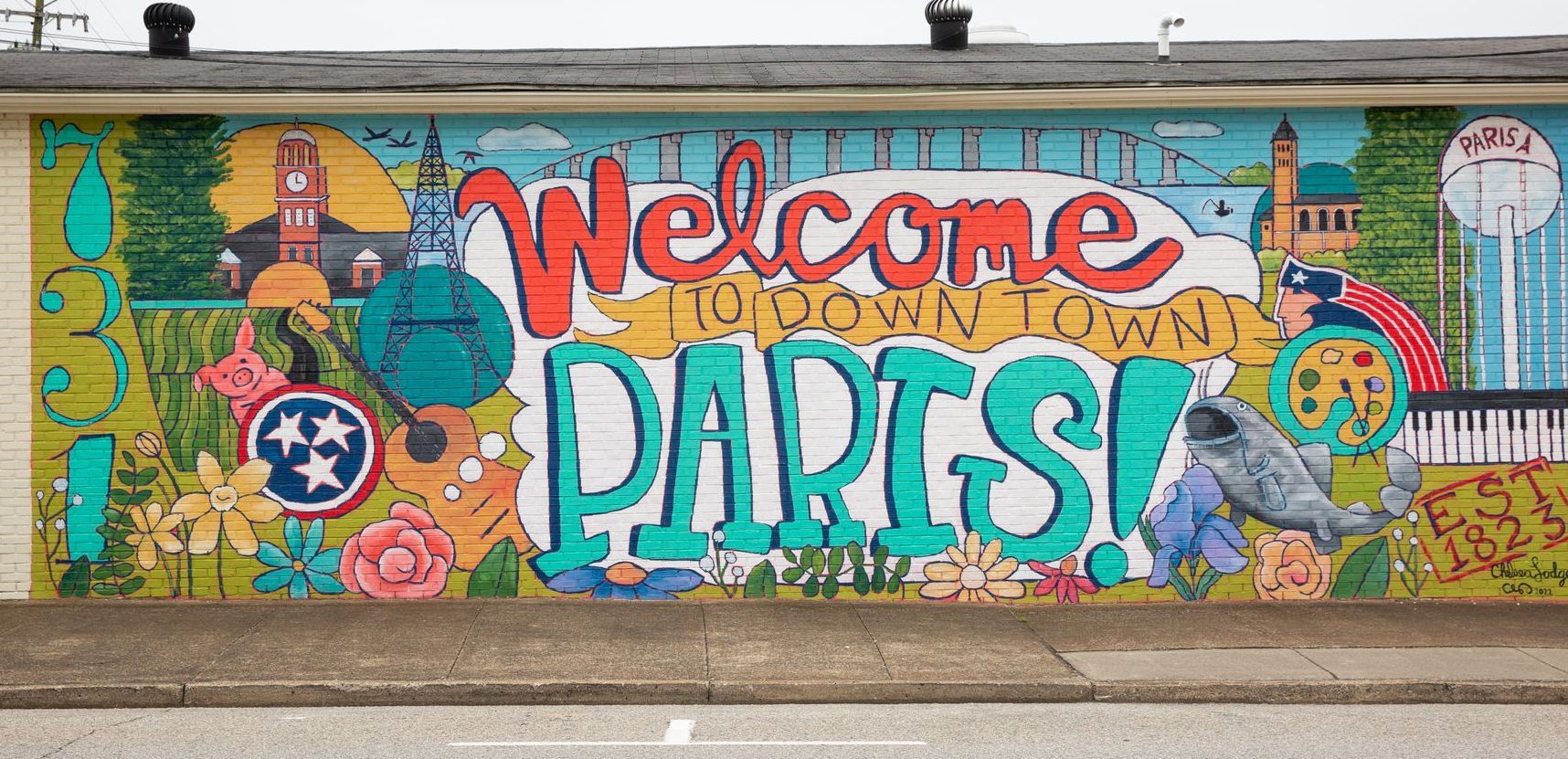 A mural on the side of a building welcomes people to parts