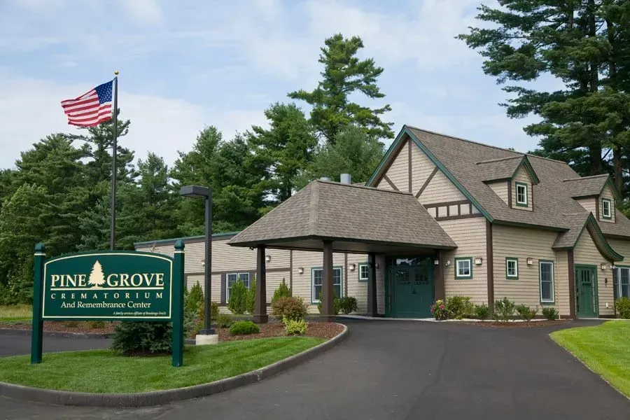 A large house with a pine grove sign in front of it