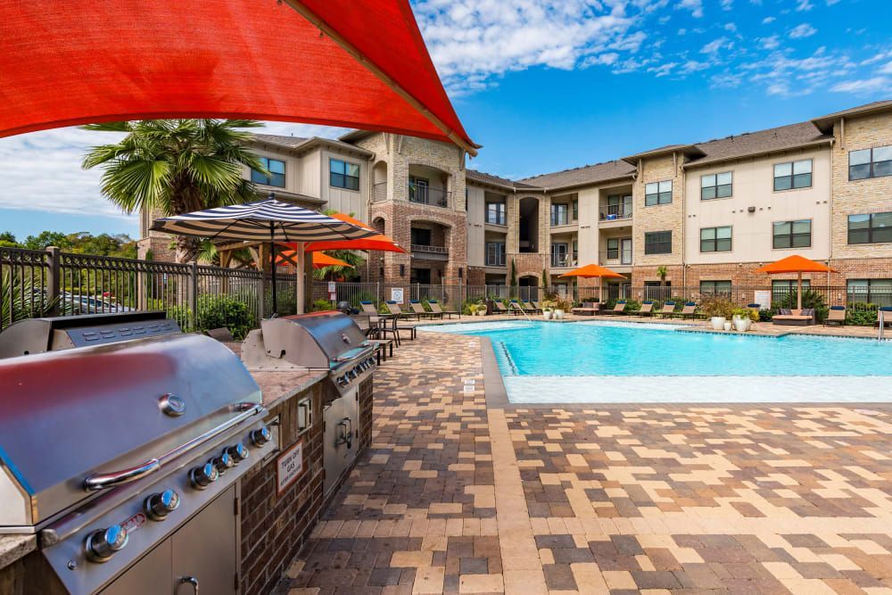 Poolside area with grills, umbrellas, and apartments at Marquis Seven Meadows