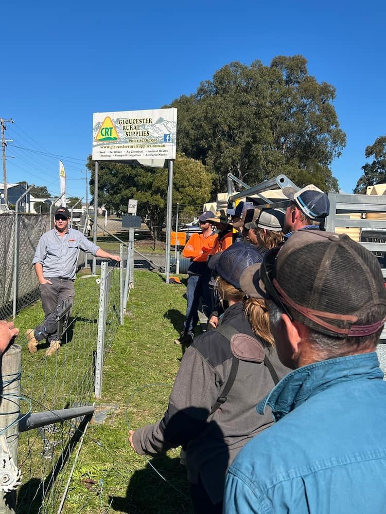 Group in Work Attire Listens to Fence Presentation Outside on Sunny Day — Gloucester Rural Supplies in Stroud, NSW