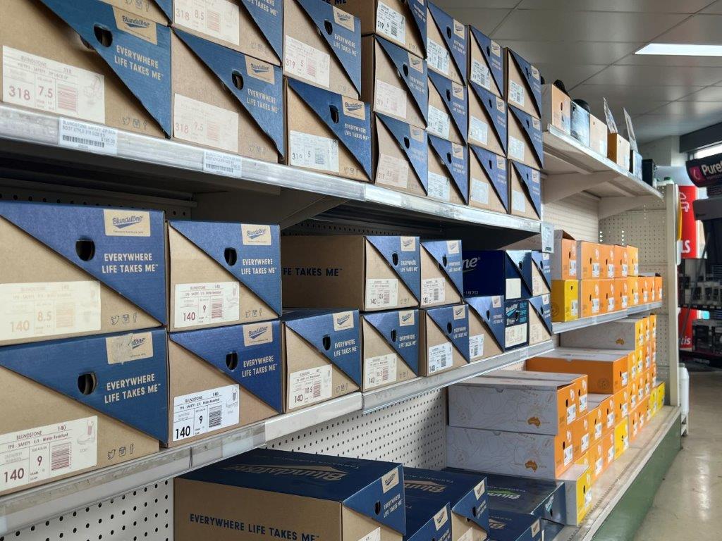 A Store Shelf Filled With Lots of Boxes of Shoes — Gloucester Rural Supplies in Gloucester, NSW