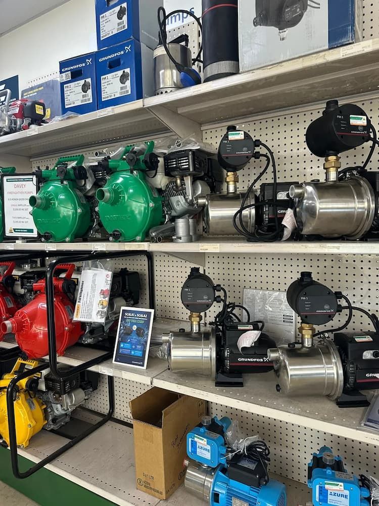 Shelves Display Green, Silver, and Blue Water Pumps in Hardware Store — Gloucester Rural Supplies in Stroud, NSW