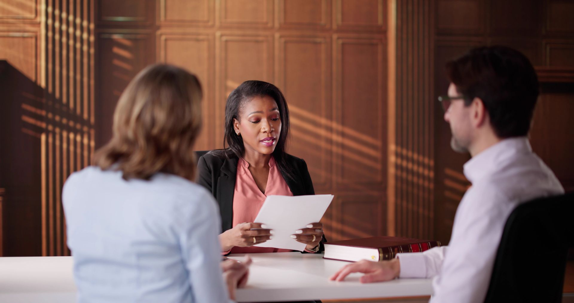 A lawyer is reading a document to a couple.