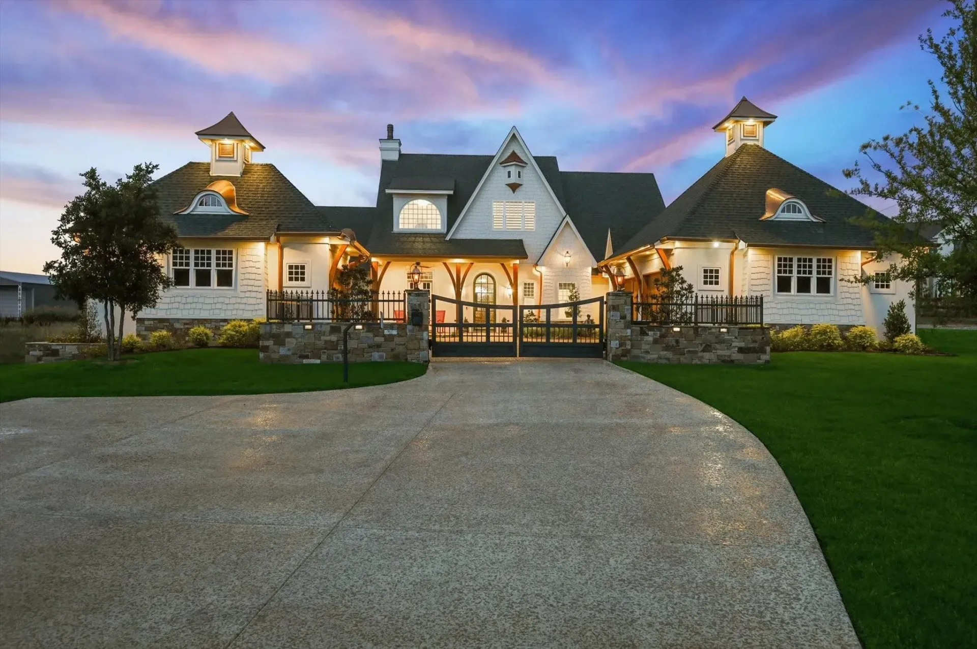 A large white house with a black roof and a driveway
