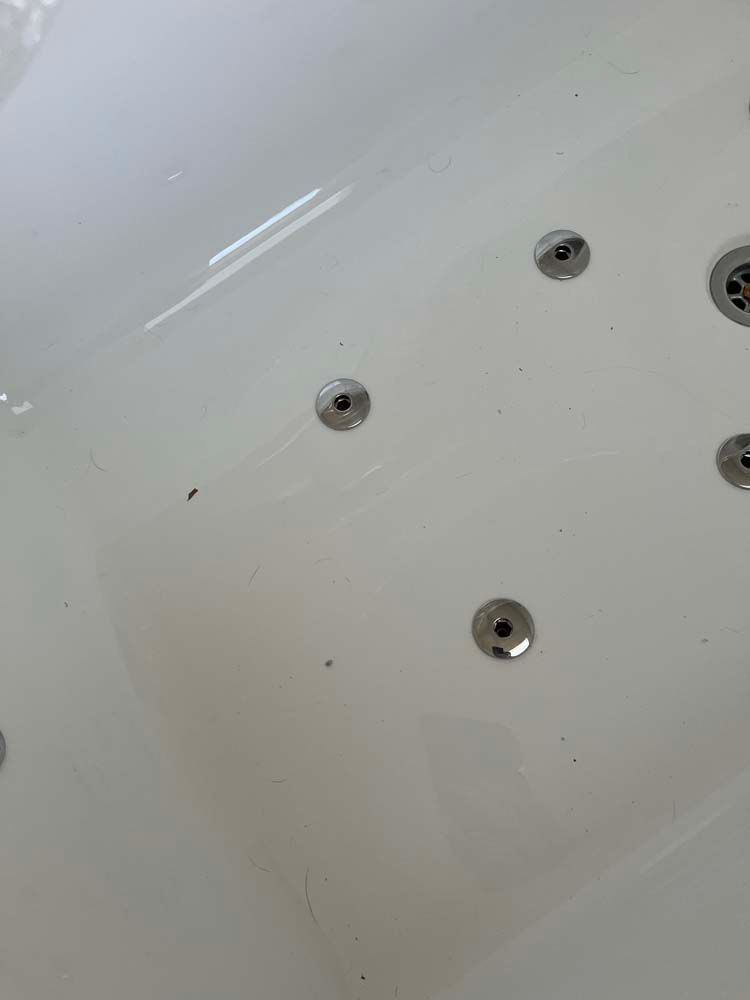 White bathtub with several silver jets on the side wall.