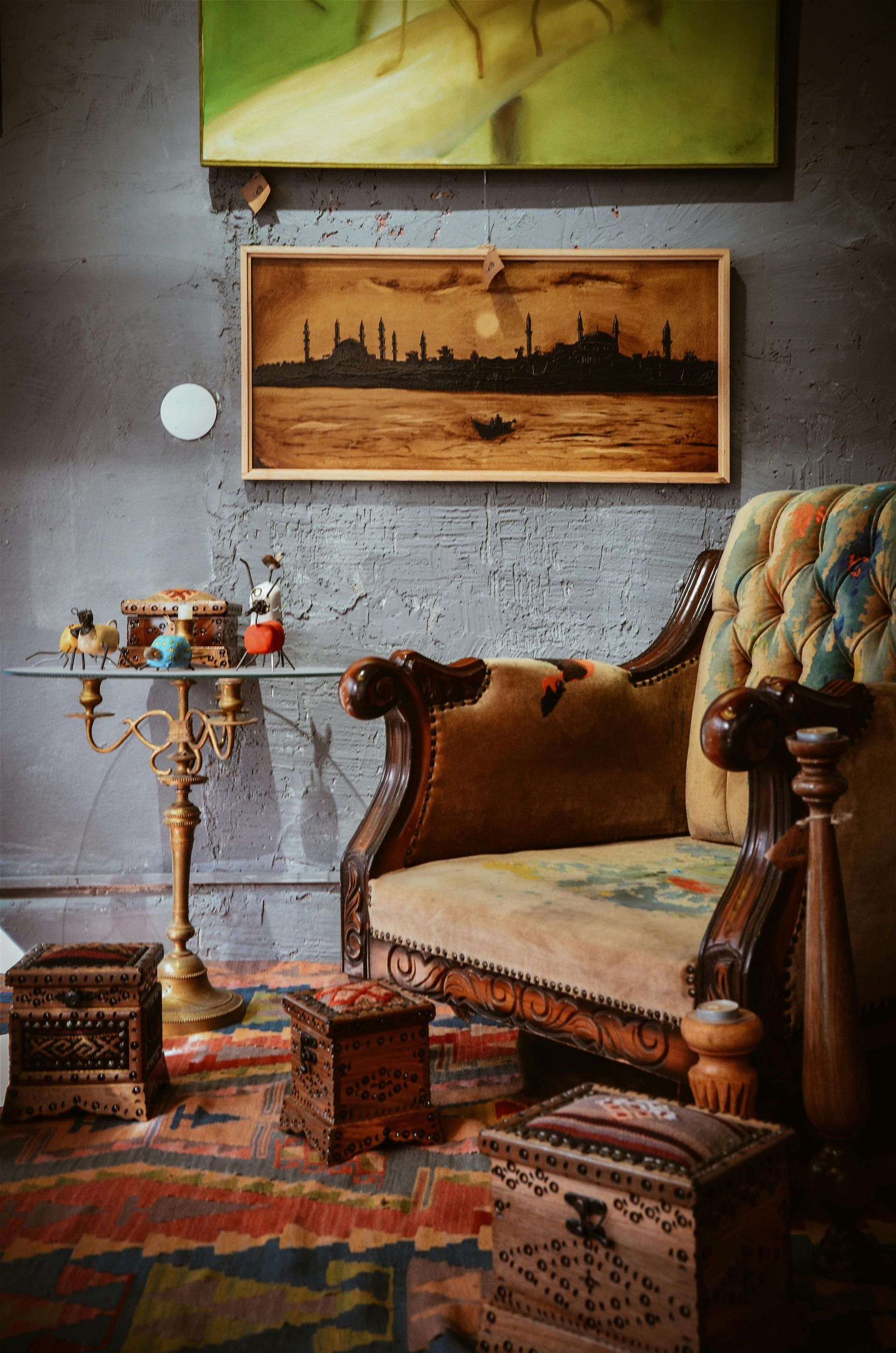 A living room with a couch and a painting on the wall.