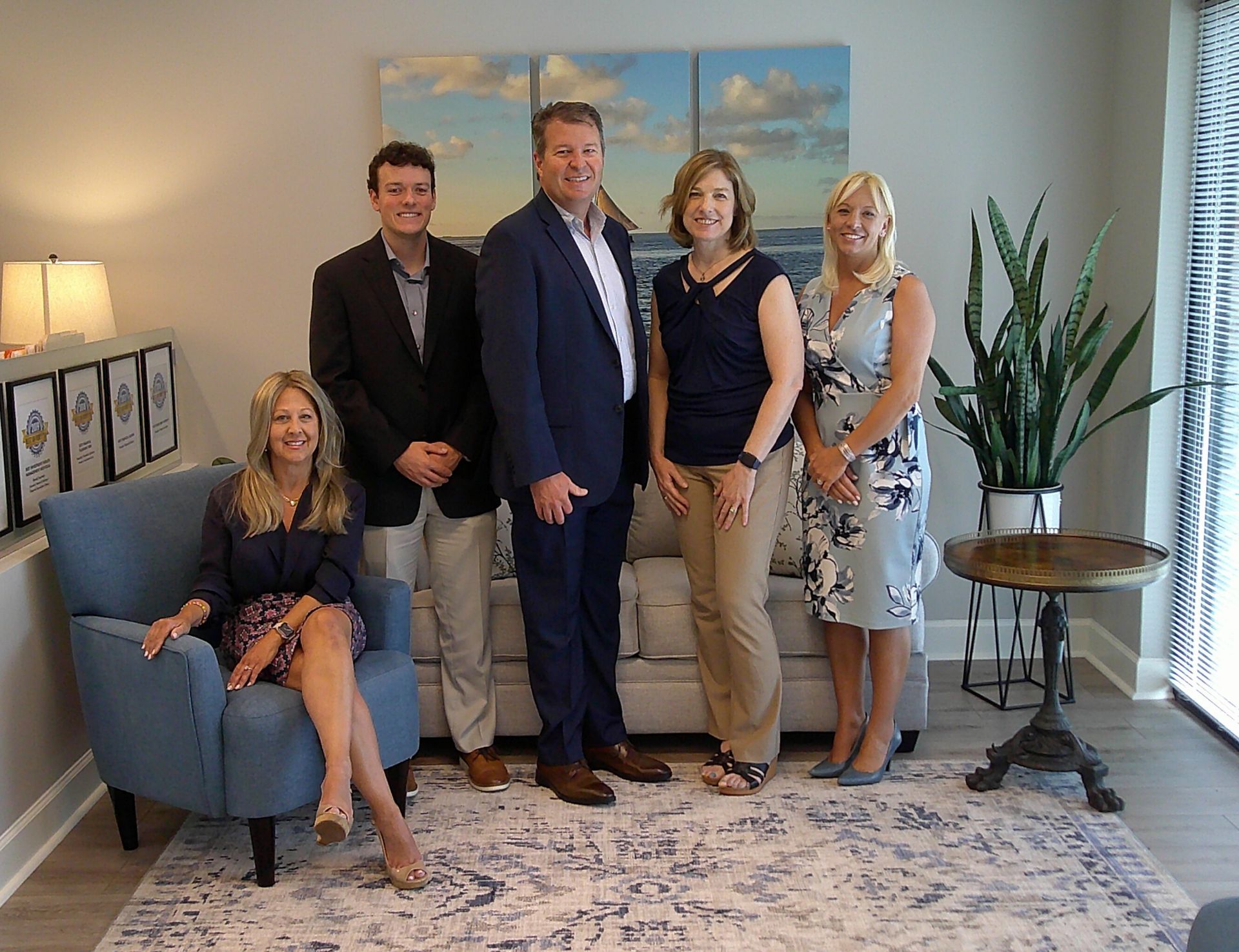A group of people are posing for a picture in a living room .