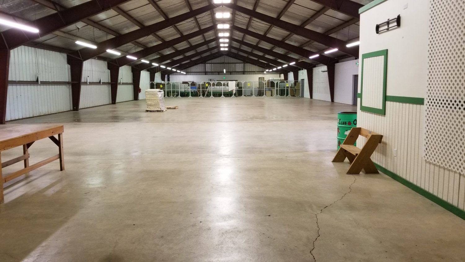 Empty indoor warehouse with a polished concrete floor and metal roof beams