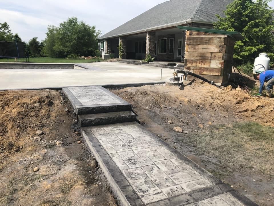 A concrete walkway is being built in front of a house