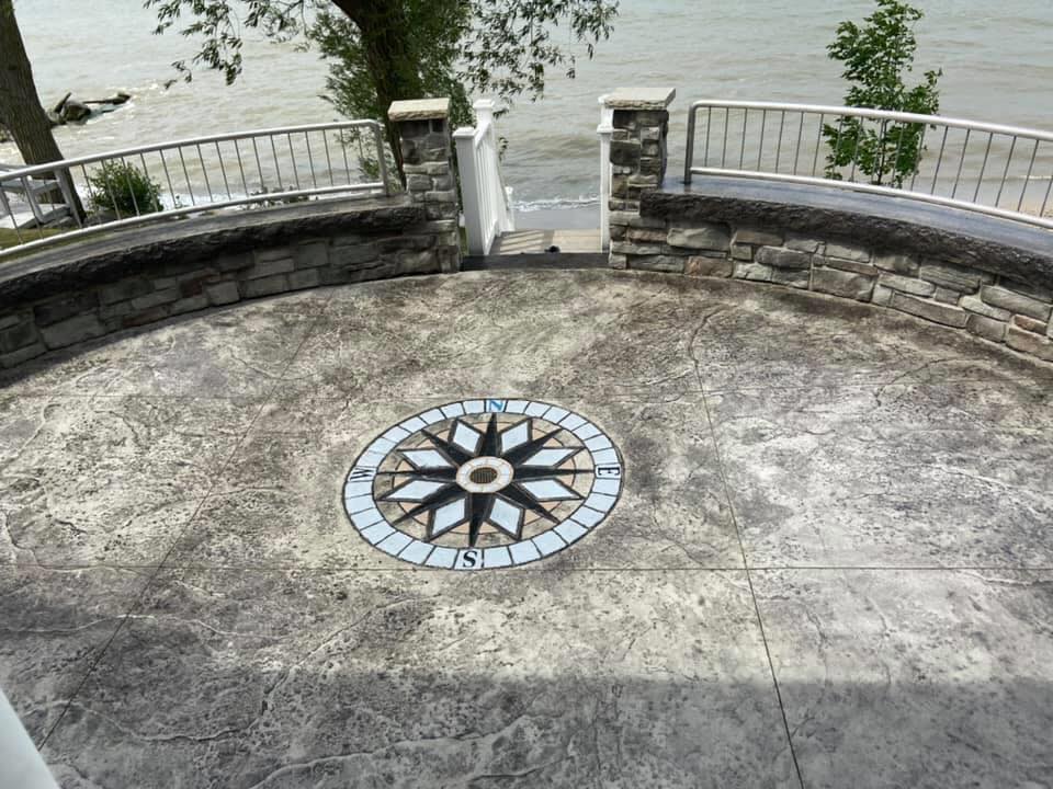 A circular concrete patio with a compass on it.