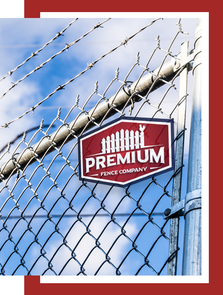 A chain link fence with barbed wire and a sign that says premium fence company