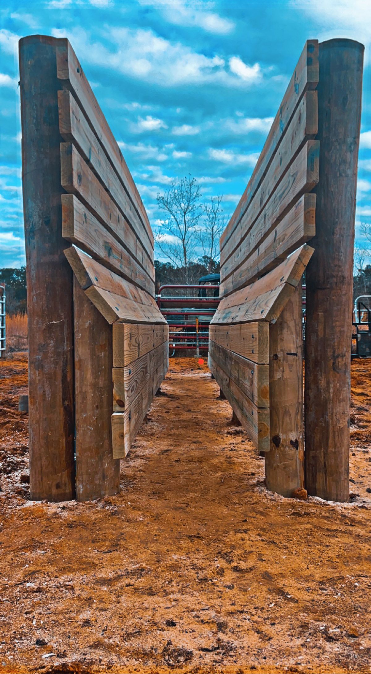 A wooden fence is sitting in the middle of a dirt field.