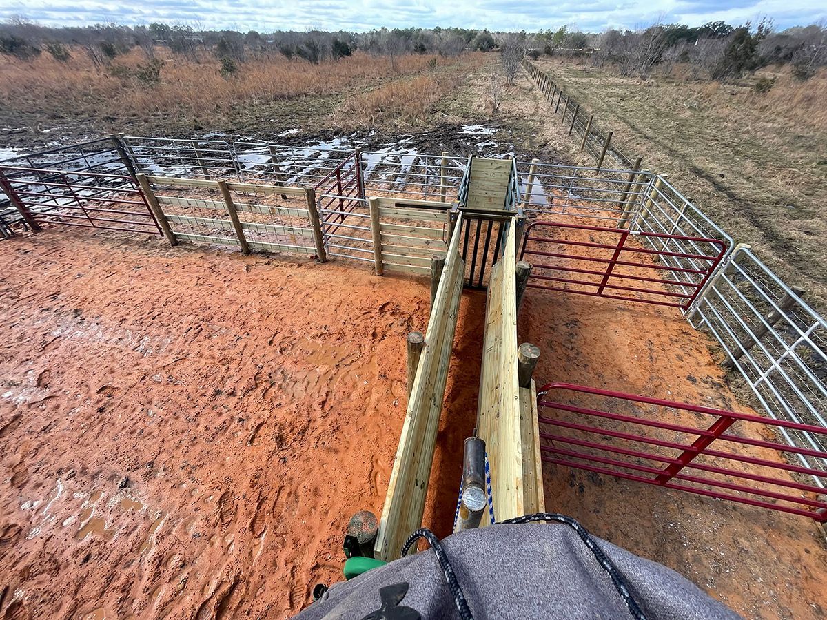 A person is riding a tractor through a muddy field.
