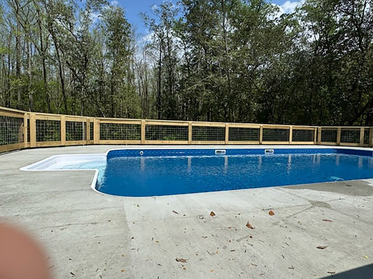 A large swimming pool with a wooden fence around it