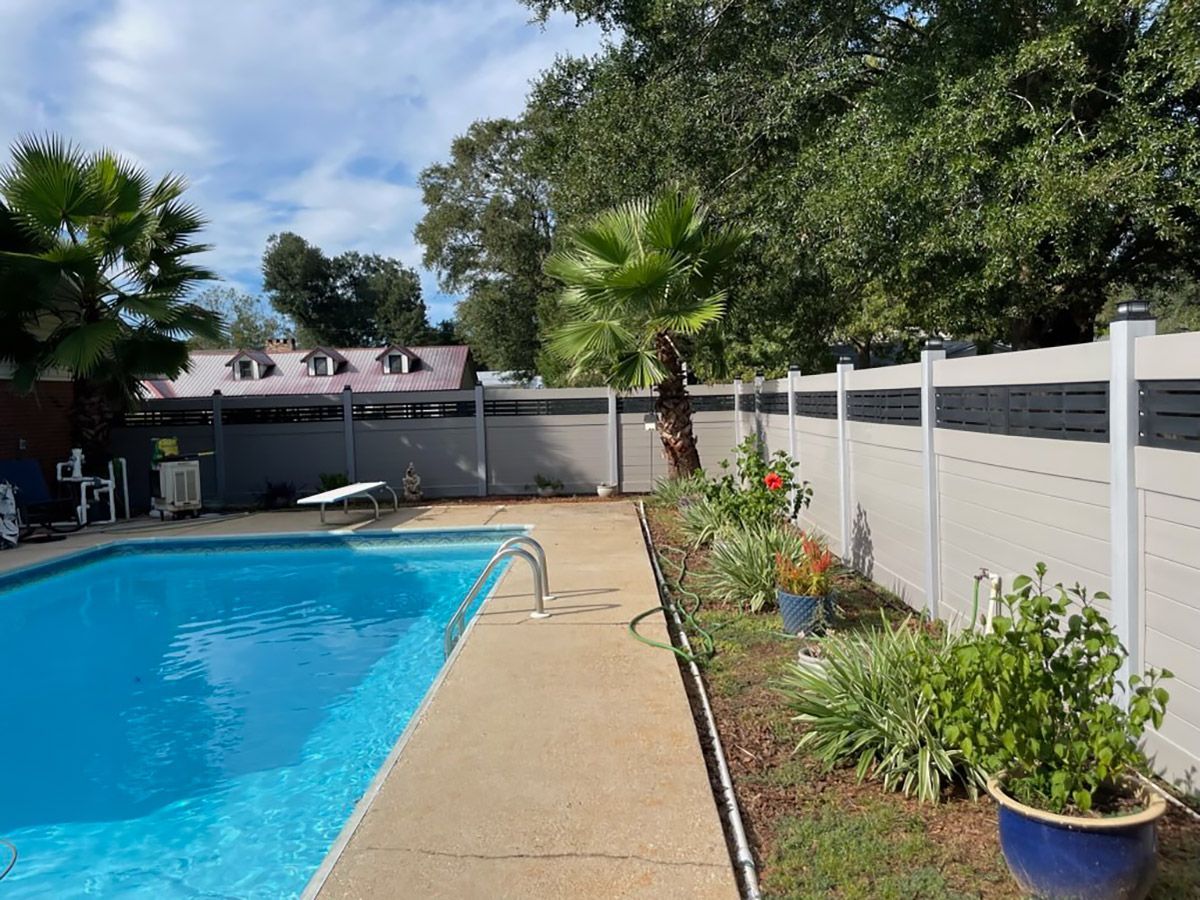 There is a large swimming pool in the backyard with a fence around it.
