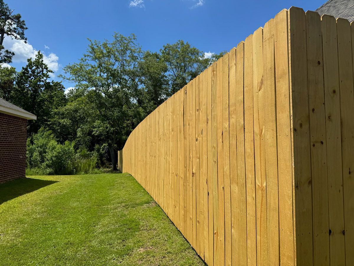 A wooden fence is sitting in the middle of a lush green field.