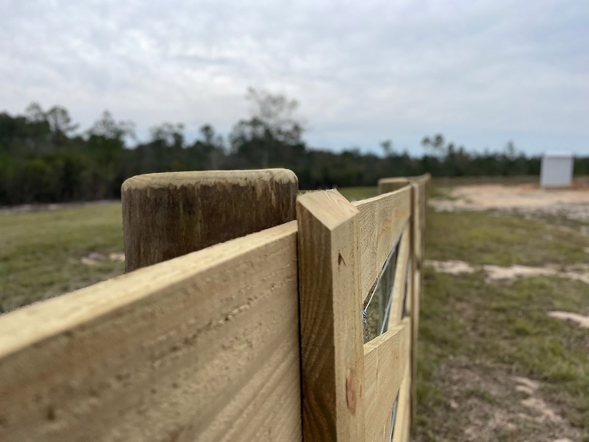 A close up of a wooden fence in a field.