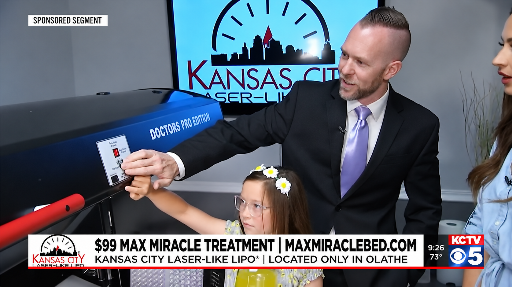 Man showing a blue package beside a woman in a TV news studio with Kansas backdrop