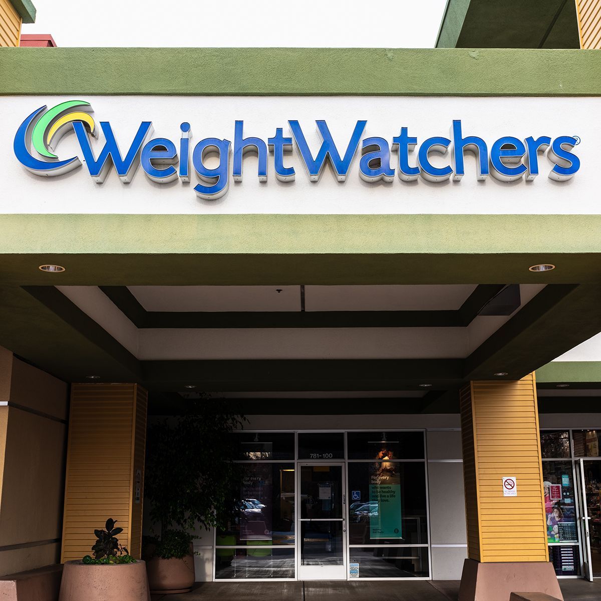 Weight Watchers storefront with blue logo, white and green trim, and glass doors.
