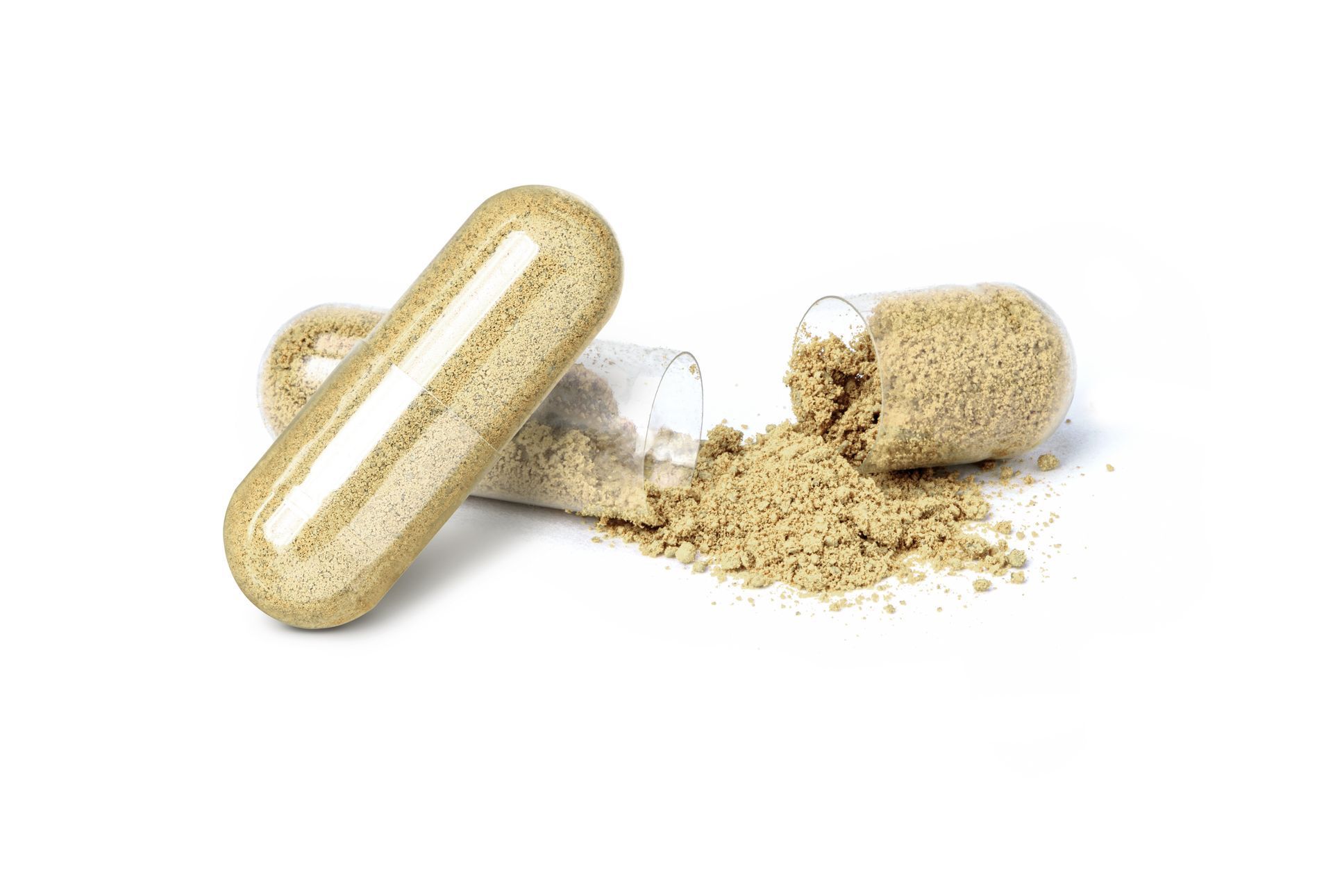 Capsule, open, spilling tan powder on a white surface.
