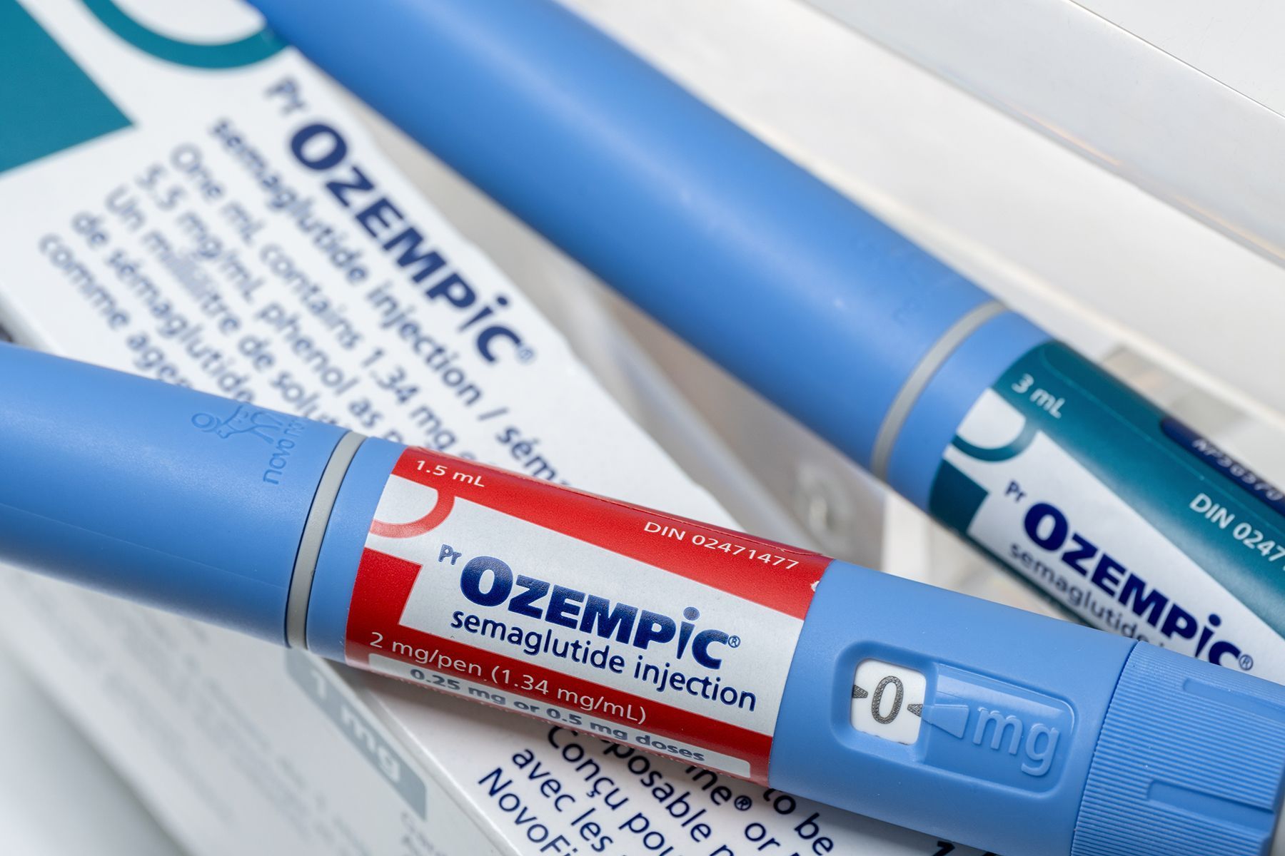 Close-up of two blue Ozempic semaglutide injection pens and a white box with product information.