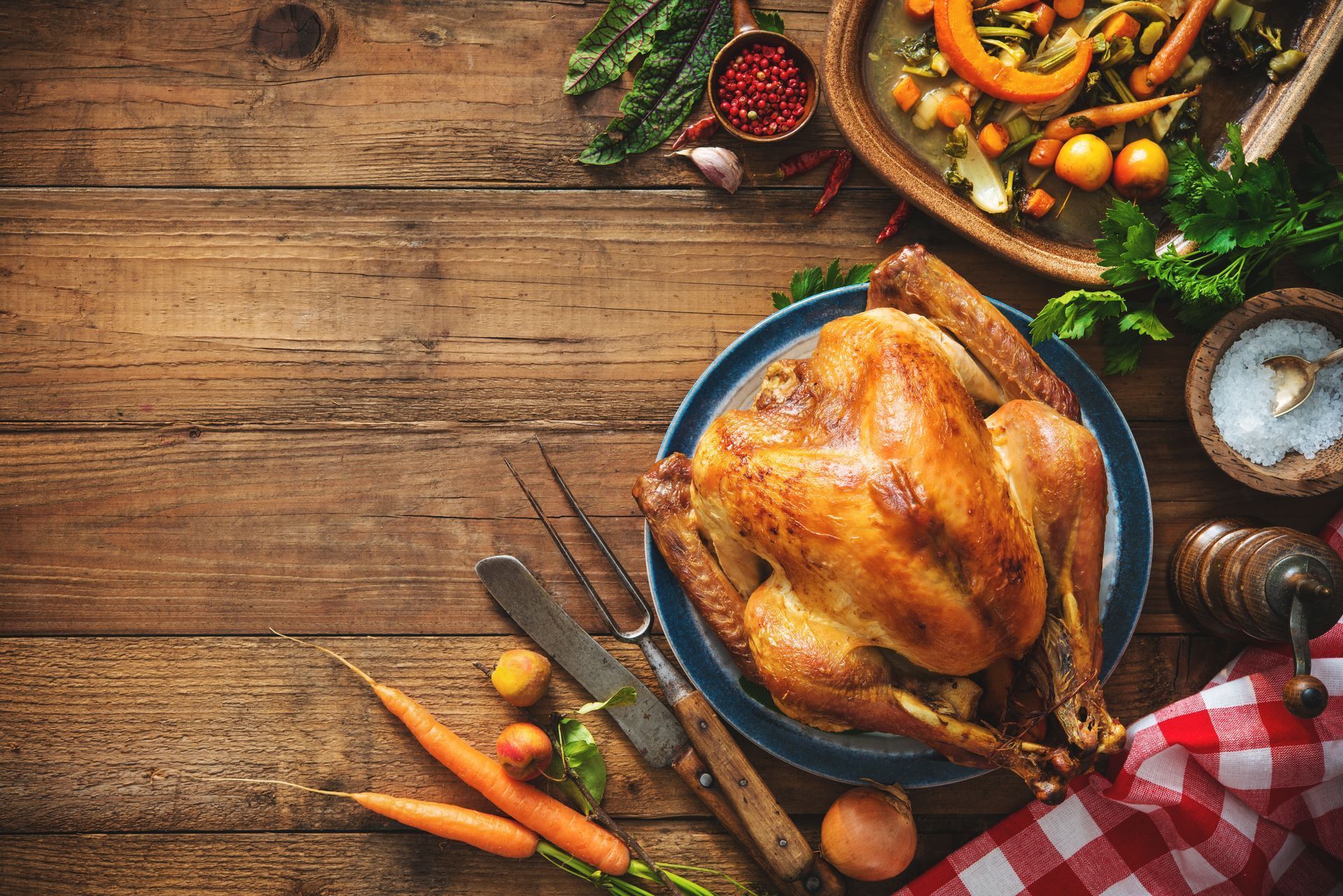 Roasted turkey and side dishes on a rustic wooden table for a holiday feast.