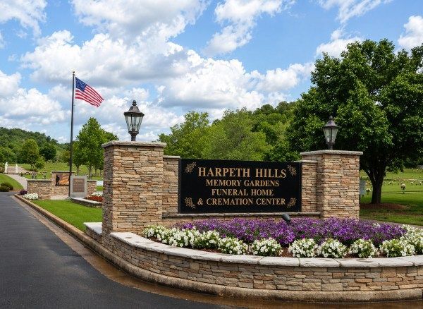 Entrance sign for Brentwood, TN Funeral Home and Cremations with stone pillars, flowers, and flag