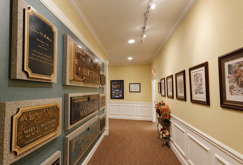 Indoor display hallway for Brentwood, TN Monuments and Headstones with bronze memorial plaques and framed art